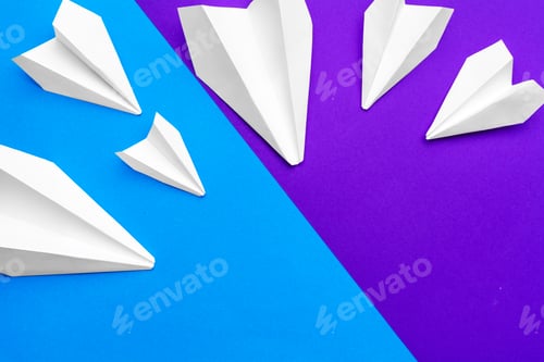 Preview: white paper airplane on a blue and purple paper background