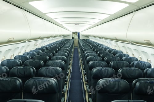 Preview: Empty airplane interior with rows of seats and dim lighting showing a quiet cabin atmosphere