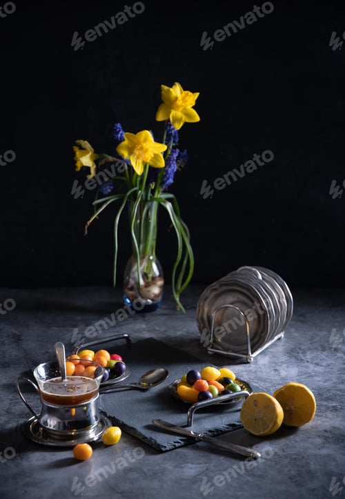 Preview: sweet multi-colored candies on plates, beautiful junk food on a dark background,a bouquet of flowers