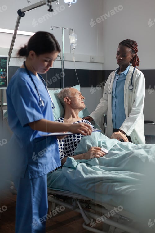 Preview: African doctor in hospital room discussing with sick senior man