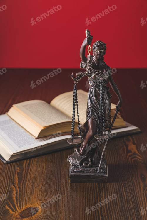 Preview: opened juridical books with lady justice statue on wooden table, law concept