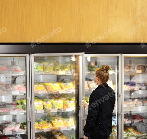 Preview: Woman Choosing Frozen Food From A Supermarket Freezer. Purchasing A Packet Of Meat At The