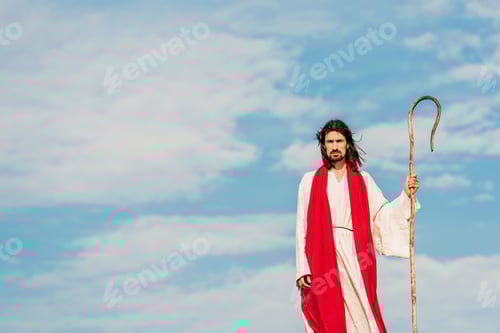Preview: handsome bearded man holding wooden cane and standing outside