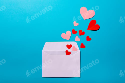 Preview: Directly above shot of hearts coming from envelope over blue background, copy space