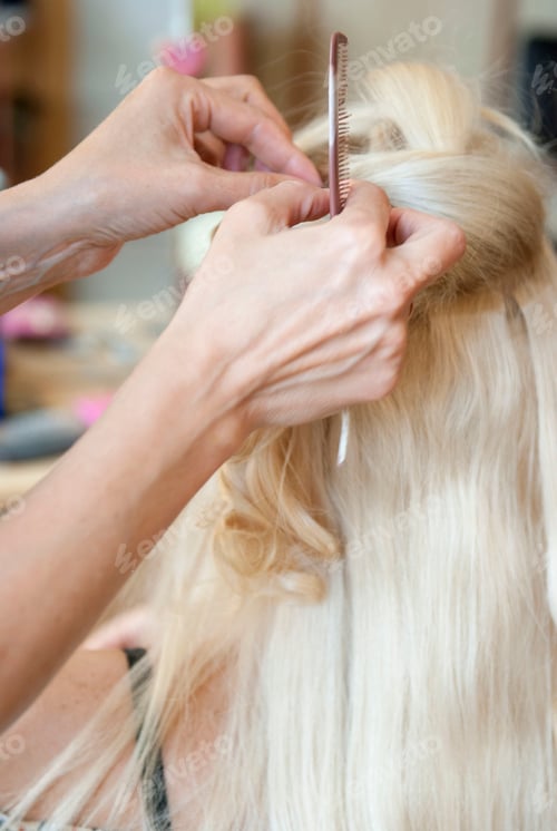 Preview: closeup of professional hairdresser hands doing beauty hairstyle