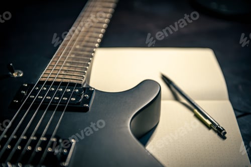 Preview: Close-up, electric guitar and notepad, concept of musical creativity.