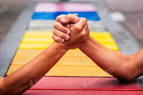 Preview: couple of people taking them hands together to help and stay united with colors on the background