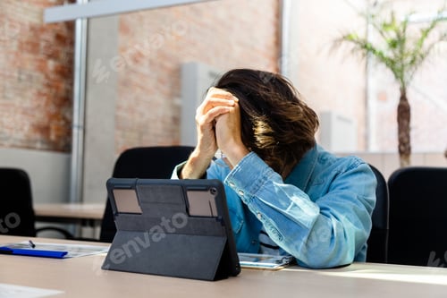 Preview: Young caucasian man frustrated and overwhelmed with work in the office. Copy space.