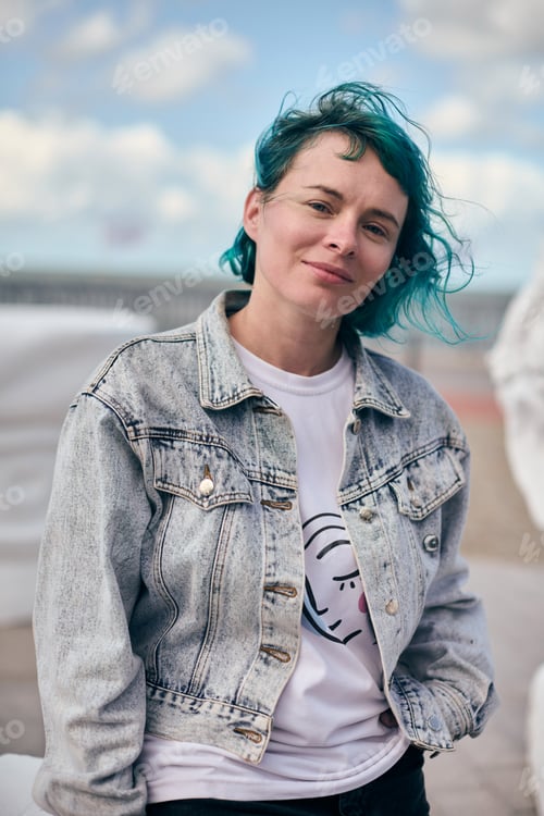 Preview: Young woman with blue hair in denim jacket outdoors