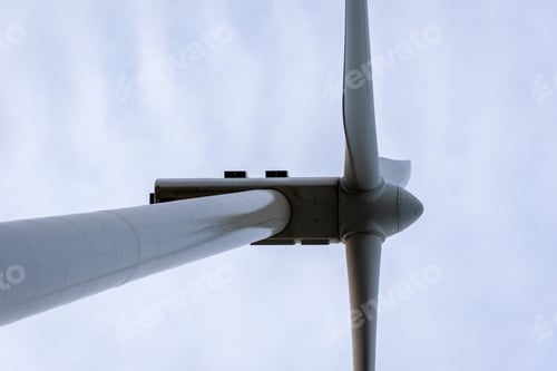 Preview: Low angle shot of a windmill for the electricity with a cloudy sky on the background