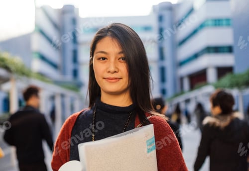 Preview: Portrait of young woman holding notebook looking at camera