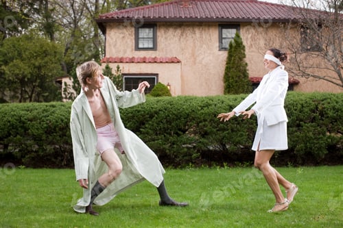 Preview: Couple fooling around in garden, woman blindfolded