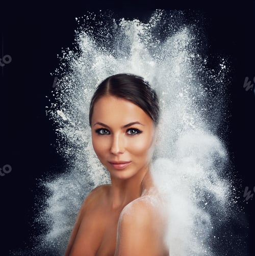 Preview: A young woman with bare shoulders being enveloped by a burst of white powder