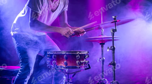 Preview: A drummer plays drums on a blue background. Beautiful special effects of light and smoke.