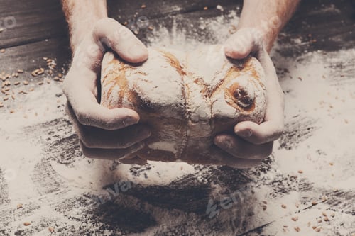 Preview: Bakery concept background. Hands hold bread loaf