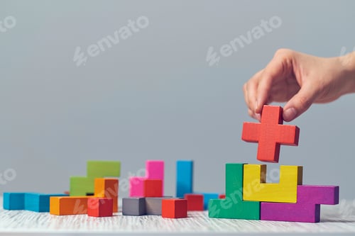 Preview: Hand holding piece of wooden block puzzle. wood cube stacking.