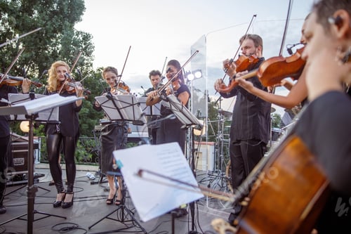 Preview: Violin players playing classic instrumental music on outdoor stage