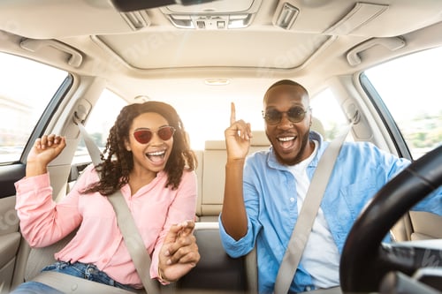 Preview: Excited black couple in sunglasses enjoying music driving luxury car