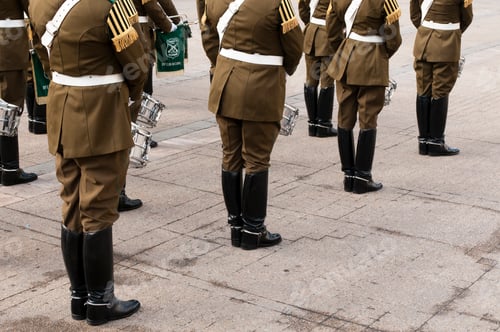 Preview: Marching band members in uniform from waist down preparing for a parade