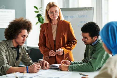 Preview: Confident teacher standing in front of intercultural students