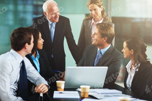 Preview: Cropped shot of a group of businesspeople gathered around a laptop in the office