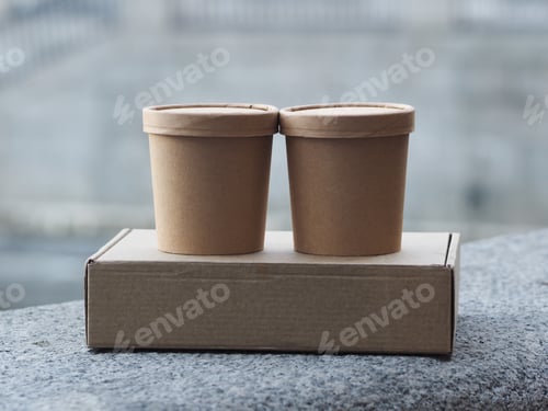 Preview: Stack of delivery boxes placed on a concrete table on the street, no people.