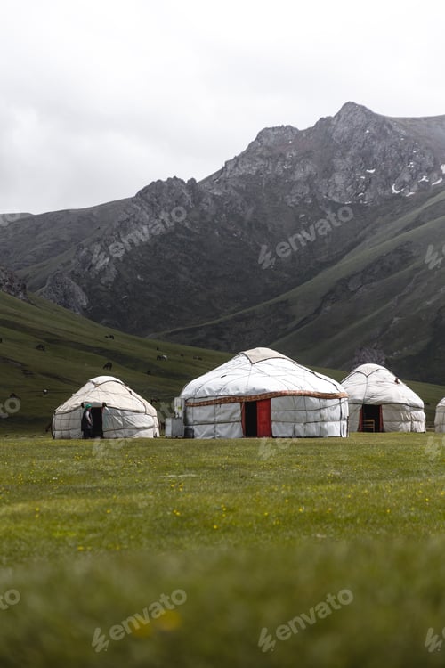 Preview: White tent in mountain valley with a cloudy sky
