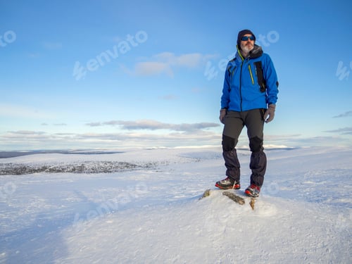 Preview: A Lonely mountaineer get rest on snowy mountain high above the clouds into the sun