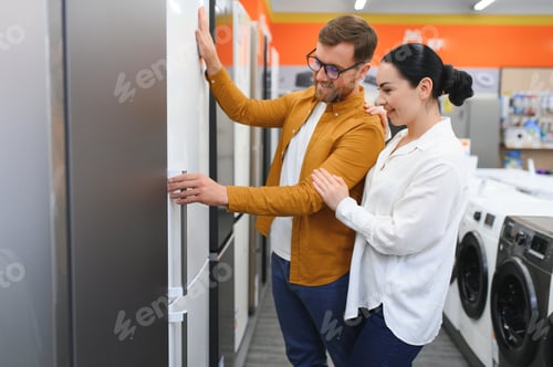 Preview: couple, satisfied customers choosing fridge in appliances store