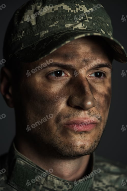 Preview: close up of with dirt on face suffering from ptsd isolated on grey