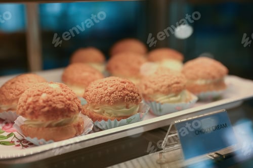 Preview: French homemade Choux cream puffs filled with vanilla cream on tray.