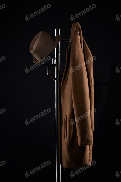 Preview: hat and classic jacket hanging on coat rack isolated on black