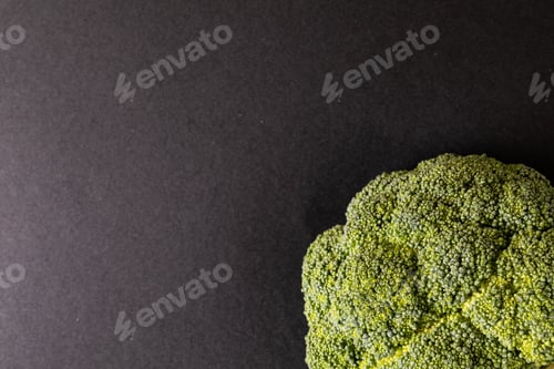 Preview: Overhead close-up of broccoli on black background with copy space