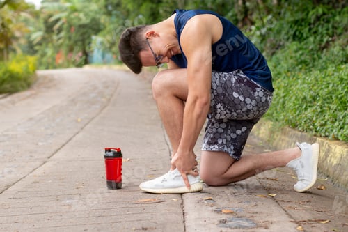 Preview: The athlete holds his ankle because it hurts. Ankle injury due to lack of warm-up before training.