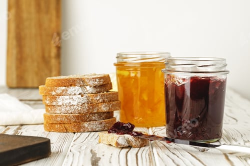 Preview: Slice of bread covered with fruit jam on wooden board