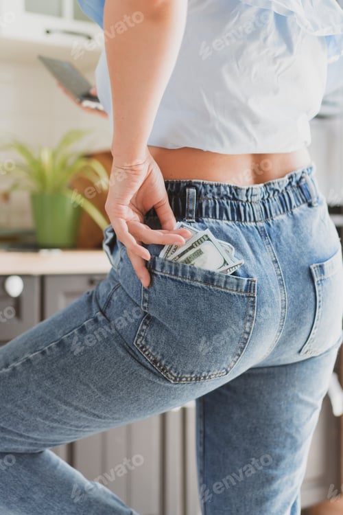 Preview: Woman's hand pulls out dollars from jeans pocket