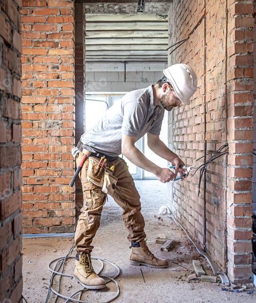 Preview: Worker is cutting wires with lineman's pliers.