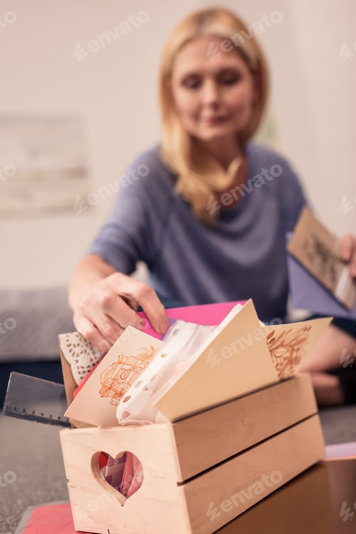 Preview: close-up view of blonde woman scrapbooking at home