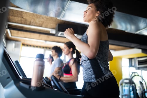 Preview: Young woman running on a treadmill in health club