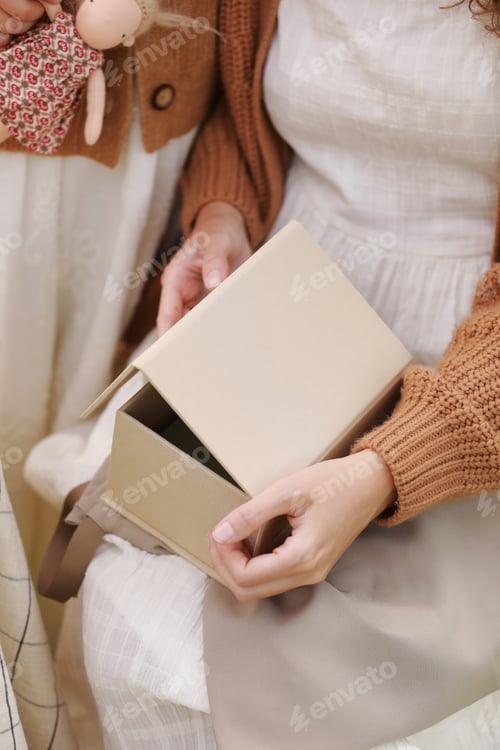 Preview: Unrecognisable woman is opening gift craft box with mock up, daughter gave her on Mother's Day.
