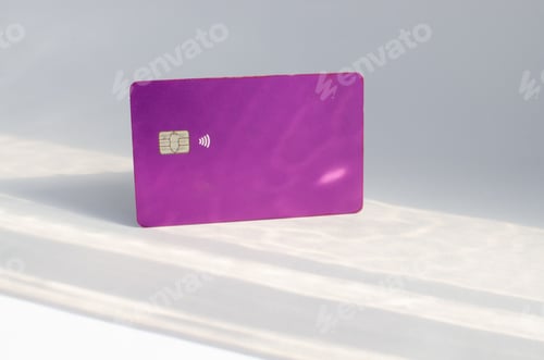 Preview: Closeup of a purple credit card isolated on an empty surface