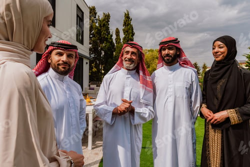 Preview: Arab multi-generational family gathering and discussing outdoors
