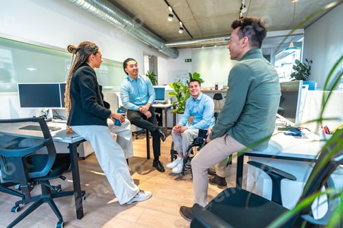 Preview: Diverse business team discussing in modern office with disabled colleague