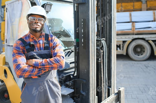 Preview: Portrait of a happy African American male worker driving forklift at workplace