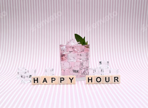Preview: happy hour as words and a glass with pale pink drink and ice cubes