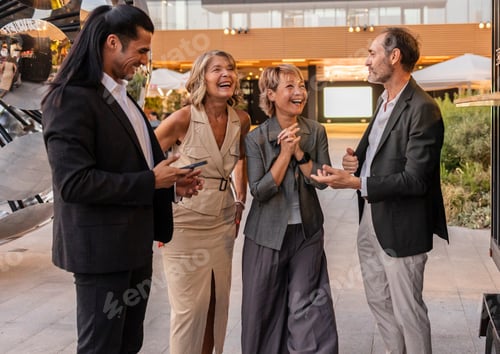 Preview: Diverse business professionals sharing laughter during outdoor networking event