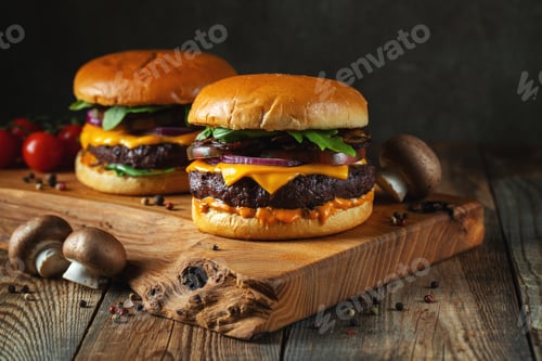 Preview: Two delicious homemade burgers of beef, cheese and mushrooms on an wooden table. Fat unhealthy food