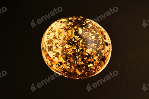 Preview: A round drop of 24k gold serum on a gold background.