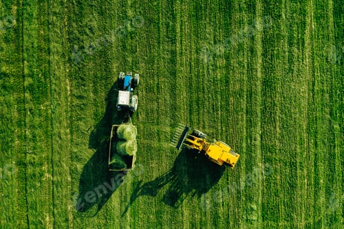 Preview: Aerial view of harvest field with tractor moving hay bale