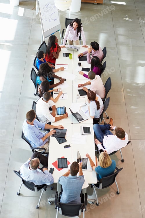 Preview: Businesswoman Addressing Meeting Around Boardroom Table